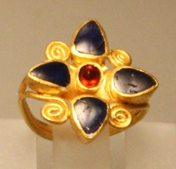 Roman gold and saphire ring, second half of the 2nd century CE. The ring has a garnet centre stone. From an unidentified marble sarcophagus in Rome. Palazzo Massimo, Rome.