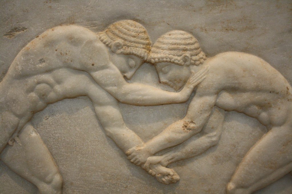 A detail of a marble funerary kouros base showing two wrestlers, 510-500 BCE. 