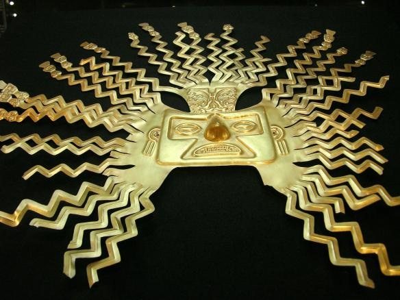 A gold-sheet mask representing the sun god Inti from the La Tolita part of the Inca empire. The design is typical of masks of Inti with zig-zag rays bursting from the head and ending in human faces or figures. (National Museum, Quito, Ecuador). 