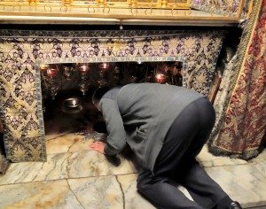 A Christian worshiper kneels at the spot in Bethlehem where Jesus is believed to have been born. (photo: Rick Steves)