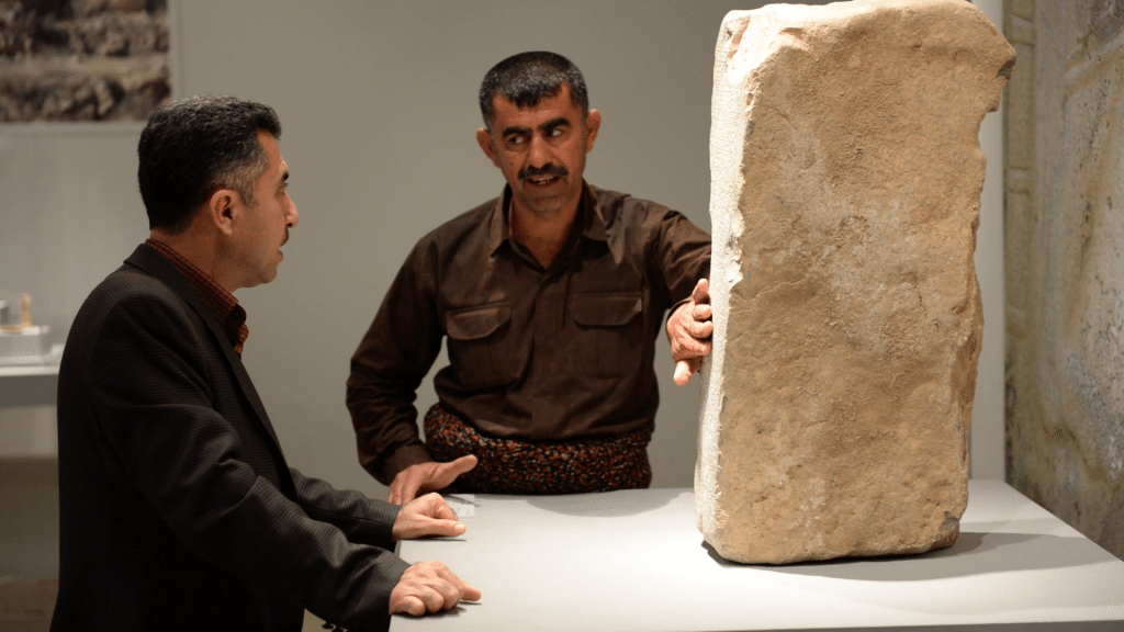 Interviewing Mr. Nejem-Alddin Ahmad (who stands between the stela and Mr. Hashim Hama Abdullah, the director of the Sulaymaniyah Museum. A snapshot using VLC media player; video interview using my Nikon D610. 