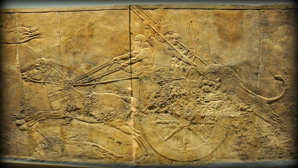 Alabaster bas-relief showing Ashurbanipal in his royal chariot hunting a lion. The lion has already hit by 2 arrows and he has leaped towards the rear part of the chariot. Two royal attendants, one holds a bow and the other one holds a spear, are trying to ward the lion of the king. The king holds a long spear with his 2 hands, thrusting forcefully upon the lion's head; the lion tries to turn his head away. From Room C of the North Palace, Nineveh (modern-day Kouyunjik, Mosul Governorate), Mesopotamia, Iraq. Circa 645-535 BCE. The British Museum, London. Photo©Osama S.M. Amin. 