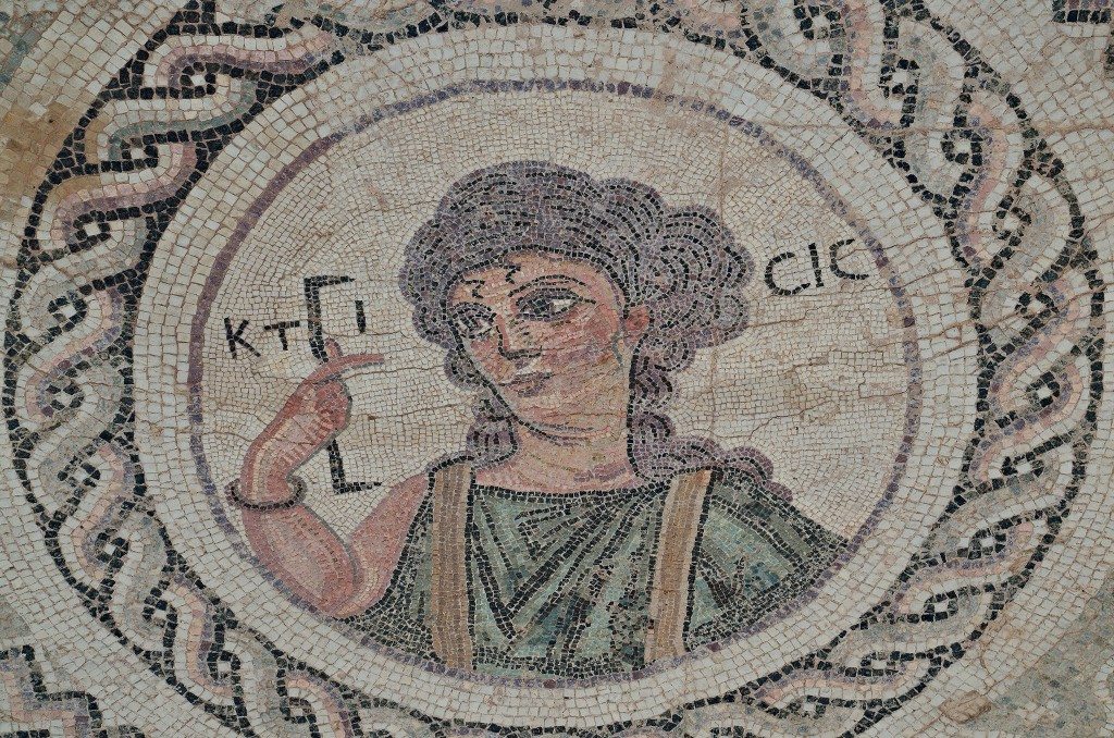 Byzantine mosaic emblema in the House of Eustolios depicting a young woman in a medallion holding a measuring instrument equating of a Roman foot, the Greek inscription identifies her as Ktisis, the personification of Creation, Kourion