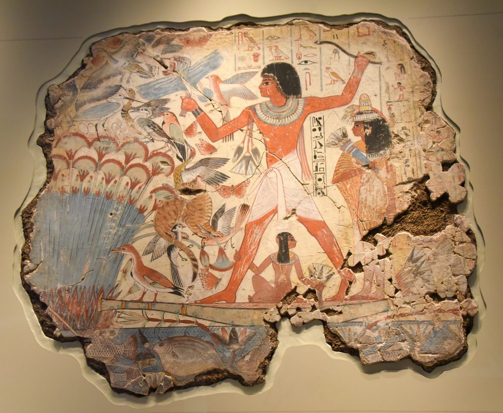 Nebamun is in a small boat, hunting birds with his wife, Hatshepsut and their young daughter in the marshes of the Nile. Scenes of leisure had already been a traditional parts of tomb-chapel decorations for centuries and they show the tomb's owner "enjoying himself and seeing beauty" in the afterlife, as the hieroglyphic caption here says. Fertile marshes were the place of rebirth and eroticisim, making this more than a simple image of recreation. The huge striding figure of Nebamun dominates, forever happy and forever young, surrounded by the rich and teeming life of the marsh. Hunting not only supplied food, but represented Nebamun's triumph over the forces of the chaos. The British Museum, London. Photo © Osama S. M. Amin. 