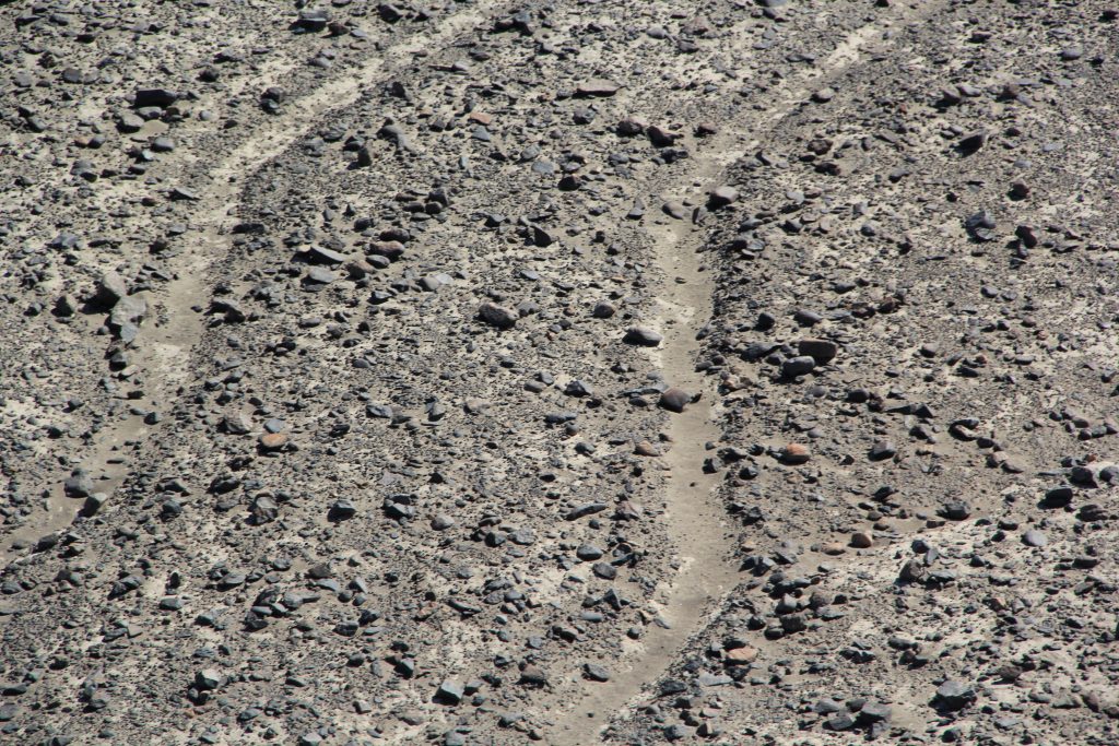 The lines were created by removing the iron-rich rocks at the surface to reveal the dirt beneath, which has a different color. In this close-up view, the shallowness and fragility of the lines are visible. Image © Caroline Cervera. Nazca lines
