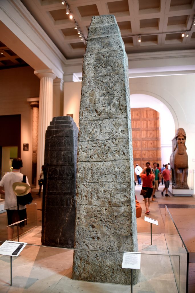 The White Obelisk of Ashurnasirpal I. This is side A. Behind it and to the left is the Black Obelisk of Shalmaneser III. On the background and to the right, a Lamassu from the North-West Palace of Ashunasirpal and a reconstructed Balawat Gat also appear. Assyrian, probably about 1050 BCE. From Mesopotamia, Nineveh (modern-day Mosul Governorate, Iraq), between the palace of Sennacherib and the Ishtar temple. The British Museum, London. Photo © Osama S. M. Amin. 